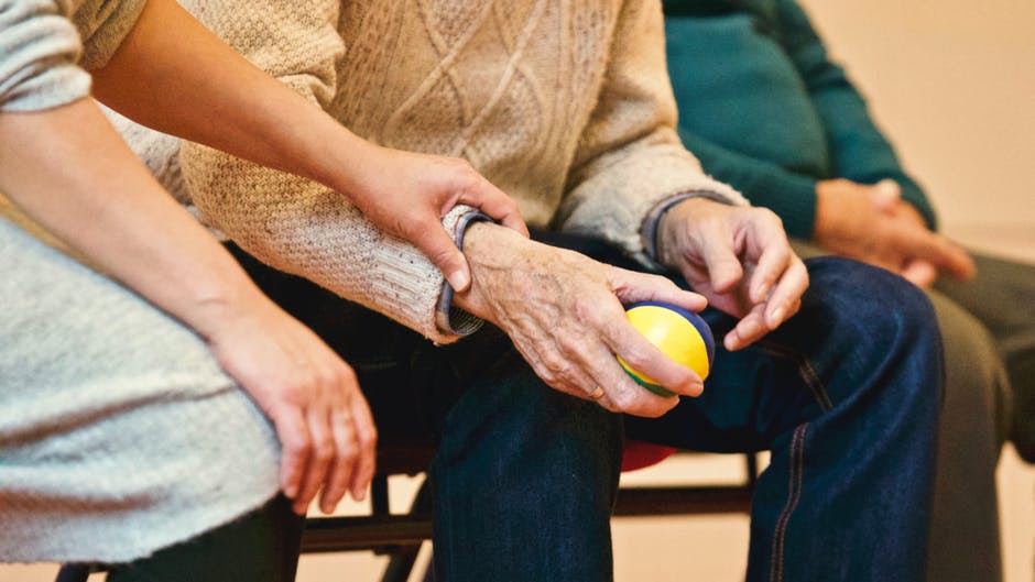 old guy with fist excercise ball in hand