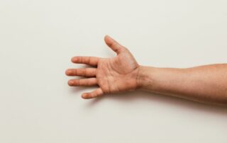 A person’s arm resting on top of a table