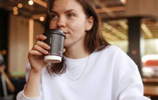 A woman with a prosthesis device drinking coffee