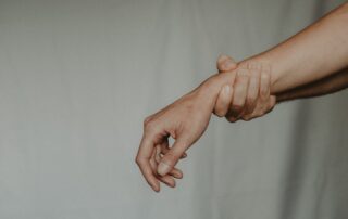 Person holding wrist due to sprain, NJ.