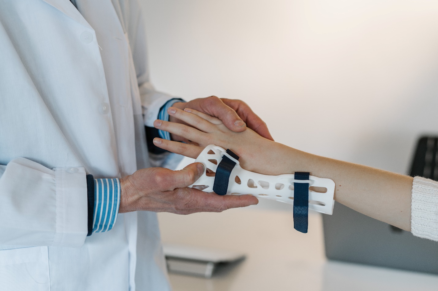 doctor attaching a brace to boy’s arm