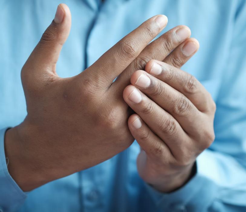 A man squeezing his fingers to massage