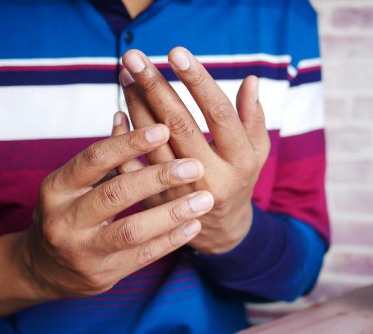A person holding their fingers in pain