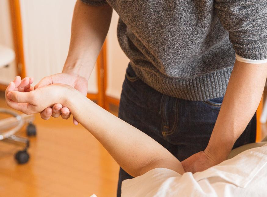 A hand therapist exercising a person's arms