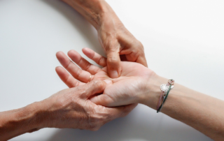 A hand therapist massaging the palm of a patient
