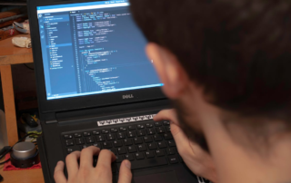A person using a laptop for coding
